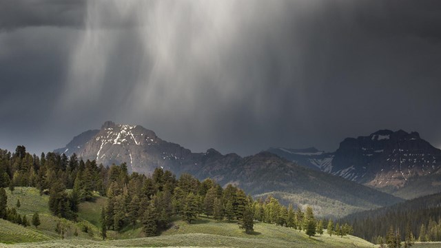 Rain clouds descend over jagged mountain peaks